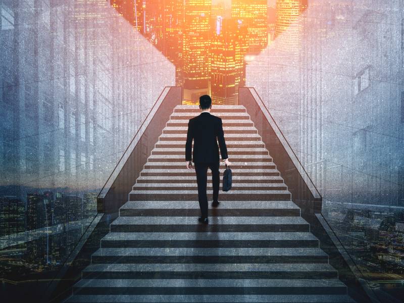Man walking up a staircase with a cityscape backdrop